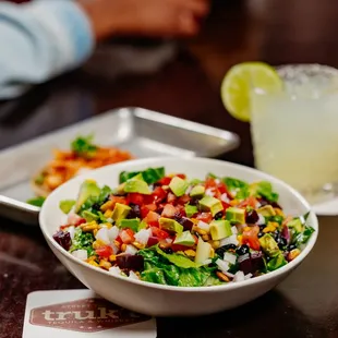 a bowl of salad and a drink