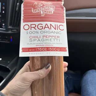 a person holding a package of organic pasta