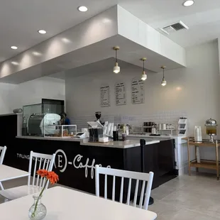 Clean, modern and minimal dining area. There&apos;s a restroom also and items to buy towards the back