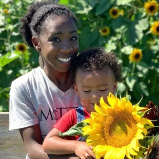 a woman and child holding a sunflower