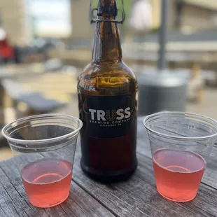 a bottle of beer and two shot glasses