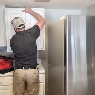 a man fixing a refrigerator