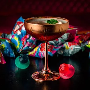 a glass of cocktail with gummy