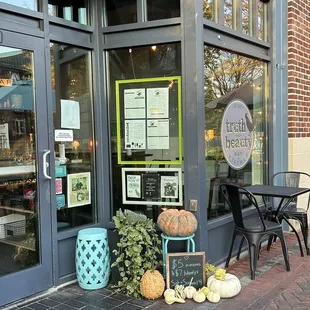 a storefront with pumpkins outside