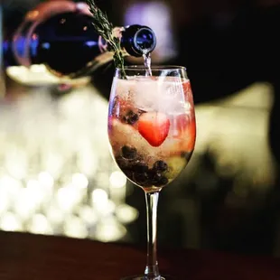 a drink being poured into a wine glass