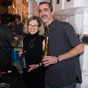 a man and a woman holding wine bottles