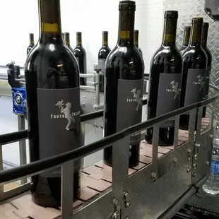 a line of wine bottles on a conveyor belt