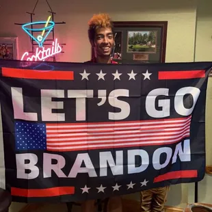a man holding a let&apos;s go brandon banner