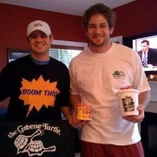 two young men holding a t - shirt