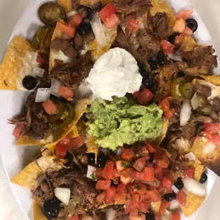 Pulled pork nachos with house-made pepperjack queso cheese sauce.