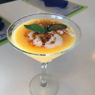 Our Peach Cobbler Martini is made with peach whiskey, peach purée, and topped with a dollop of whipped cream and cinnamon.