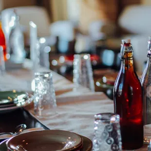 a table set with wine bottles and plates