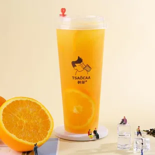 a glass of orange juice and miniature figurines