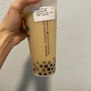 a hand holding a cup of bubble tea