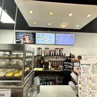 a restaurant counter with menus on the wall