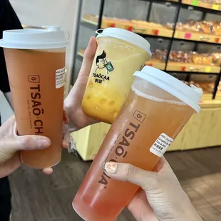 two people holding cups of iced tea