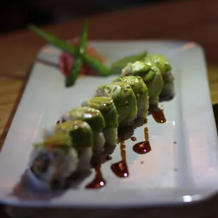 a sushi roll on a plate with sauce