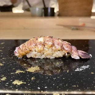 a piece of sushi on a black plate