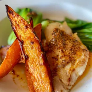 a plate of food with chicken, carrots, and broccoli