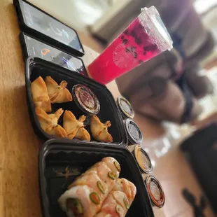 two trays of food and a drink