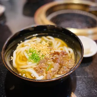 a bowl of noodles with meat and vegetables