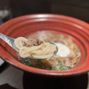 a spoon full of udon noodles