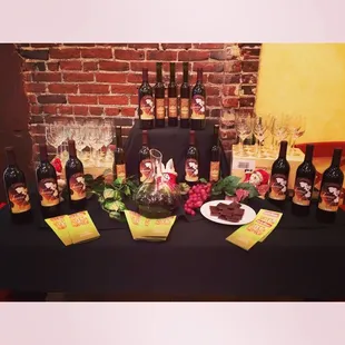 a table with wine bottles and wine glasses