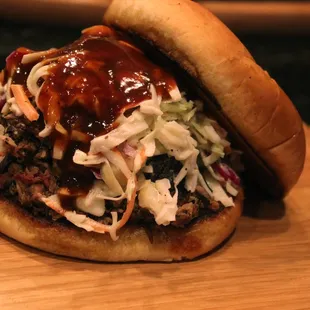 a pulled pork sandwich with coleslaw and barbecue sauce