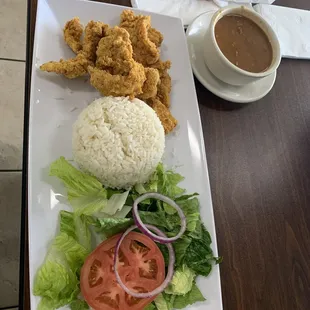 Pollo Empanizado con Arroz y Habichuela con una ensalada.