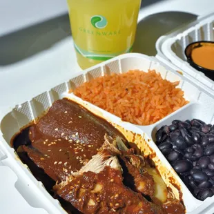 Mole enchiladas with a pineapple drink. The mole is dark and rich.