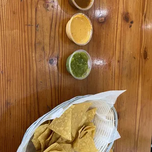 Chips and salsa one of them is a spicy peanut salsa