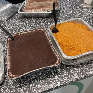 Half tray of black beans and Mexican rice