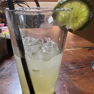 a glass of lemonade and a lime slice