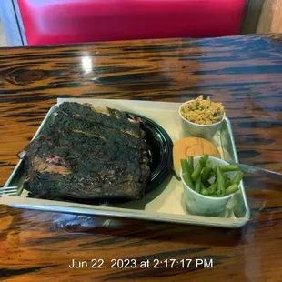 Half rack of ribs with rice and green beans.