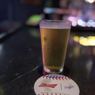 a pint of beer on a baseball coaster