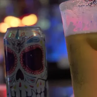 a glass of beer and a can of beer