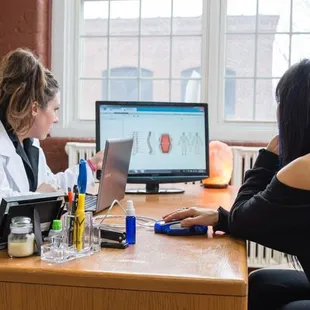 Anna Marie Blessing, B.MSc going over a Biofeedback Health Report with a client.