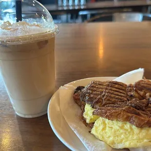 Egg croissant sandwich with bacon and pepper jack. Caramel macchiato iced with whipped cream.