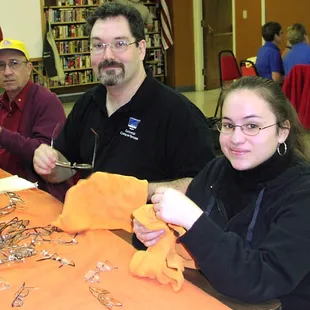 Erik Johnson and Kassandra Garcia cleaning eyeglasses to help support the Tucson Downtown Lions Club.