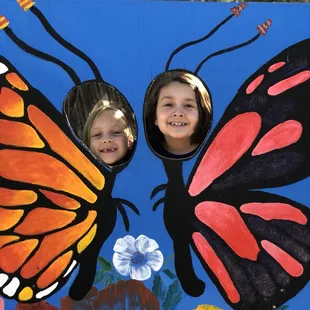 two children looking through a butterfly kite