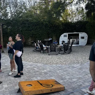 Cornhole area and a cool RV where you can sit and drink