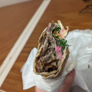 a hand holding a sandwich