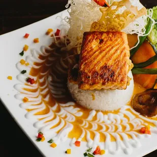 Grilled filet of salmon in a panang curry sauce, with fried eggplant and green beans over jasmine rice