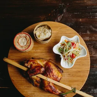 Kai Yang - Grilled marinated half chicken served with papaya salad and sticky rice