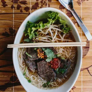 Braised beef noodle soup with cilantro, asian celery, bean sprouts and crushed peanuts