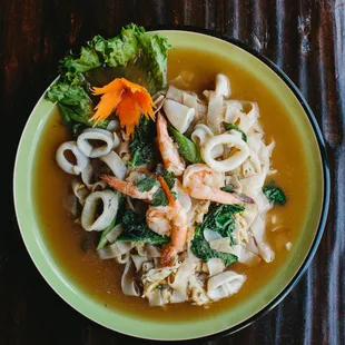 Shrimp and calamari with flat rice noodles in soy bean gravy and Chinese broccoli