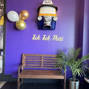 a wooden bench in front of a purple wall