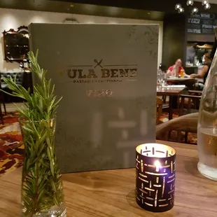 a candle and menu on a table