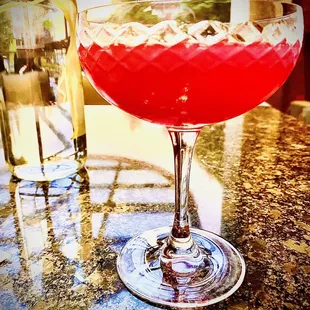 a glass of red liquid with ice cubes