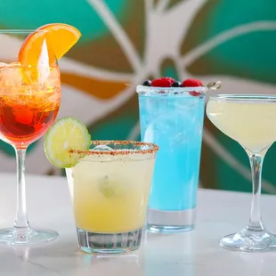 Four of our signature cocktails: Aperol Spritz, Spicy Mango Margarita, Santa Fe Blue, and our French 75.